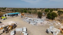 Machinery parked in the stone yard beside stacked material