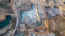 Stepped quarry basin with water pockets and exposed rock faces