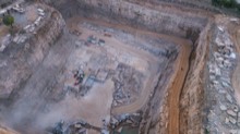 Squared-off quarry pit with a prepared floor at dusk